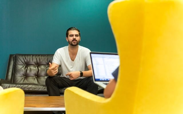 Casual office meeting with professionals discussing business ideas in a modern, comfortable setting.