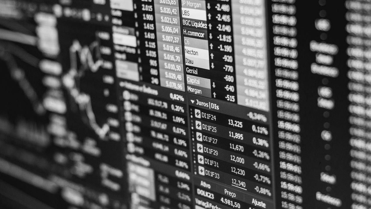 Monochrome image of stock market data on a screen, depicting financial information and trends.