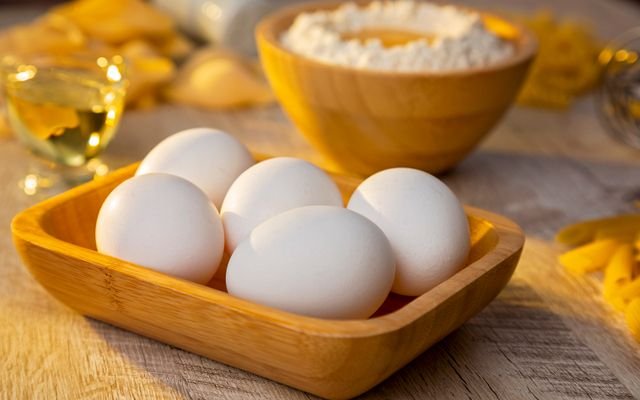 A warm, rustic photo featuring eggs and flour in a wooden setting, ideal for baking themes.