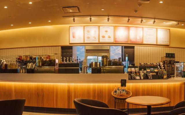 Spacious coffee shop interior with illuminated counter, perfect for a cozy gathering.