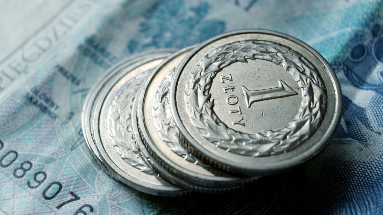 Close-up of Polish zloty coins stacked on a banknote. Financial concept.