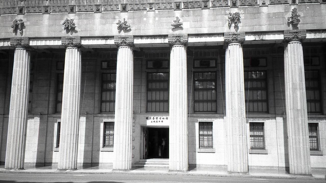 Monochrome view of the Taiwan Land Bank in Taipei showcasing neoclassical architecture.