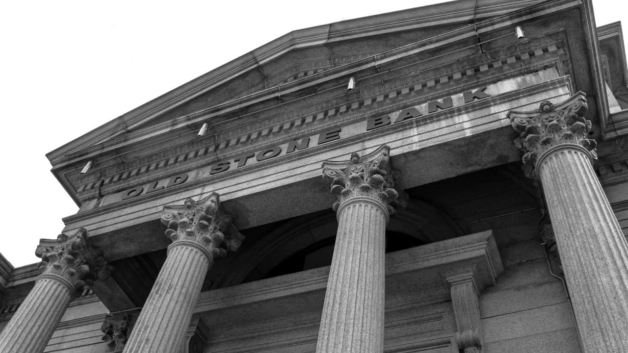 Black and white photo of the historic Old Stone Bank showcasing classical columns and architectural detail.