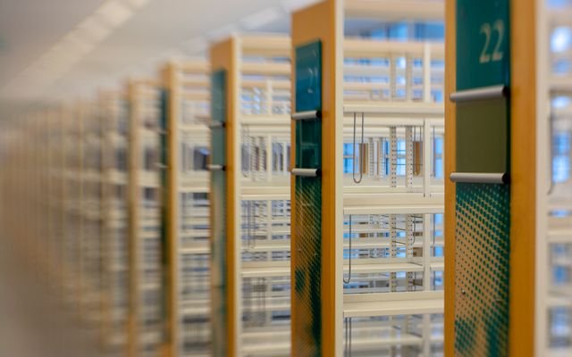 A modern library with rows of empty numbered bookshelves, offering a blurred perspective.