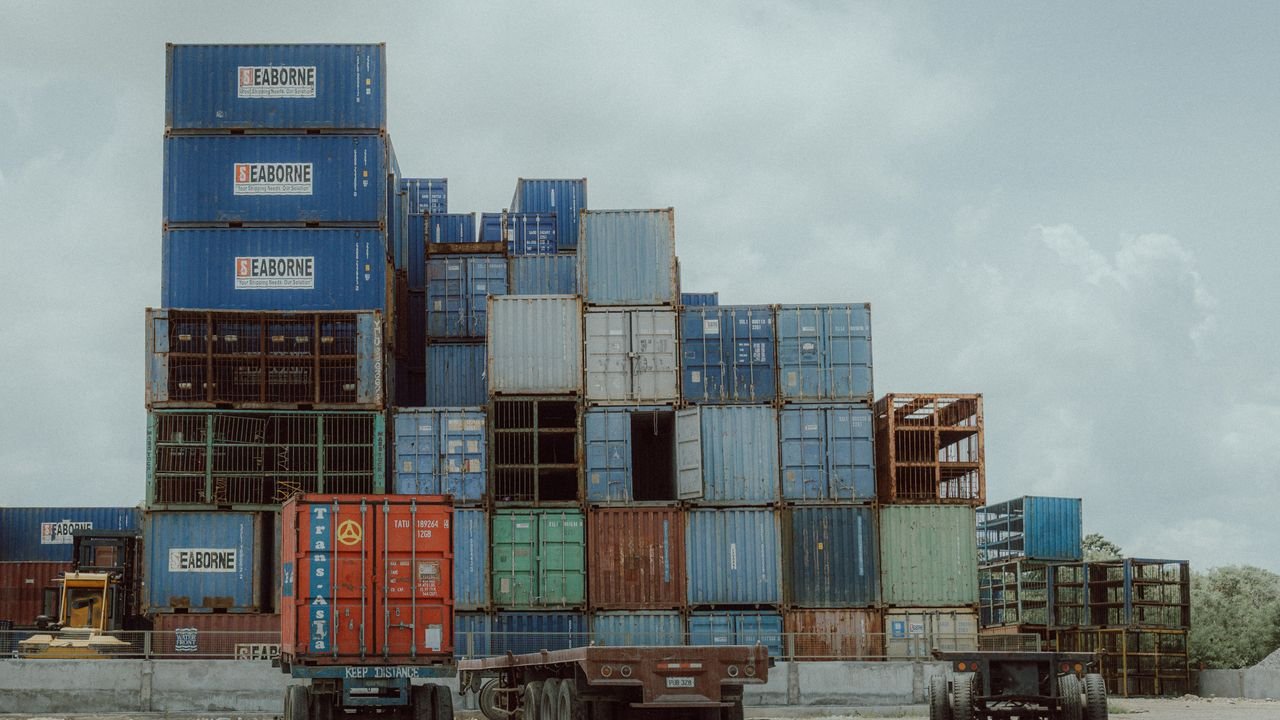 Colorful shipping containers stacked at a port, illustrating global logistics and commerce.