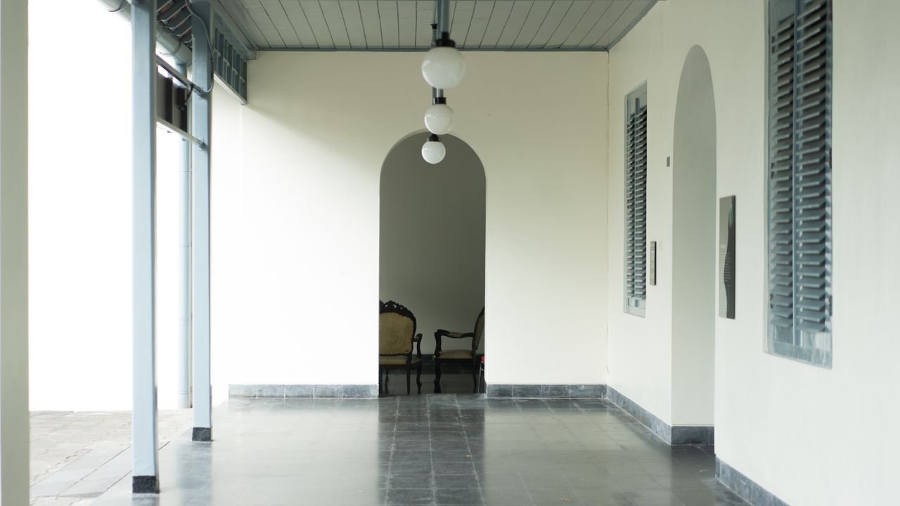 A serene interior hallway with an archway and classic furniture in Kuta, Bali.