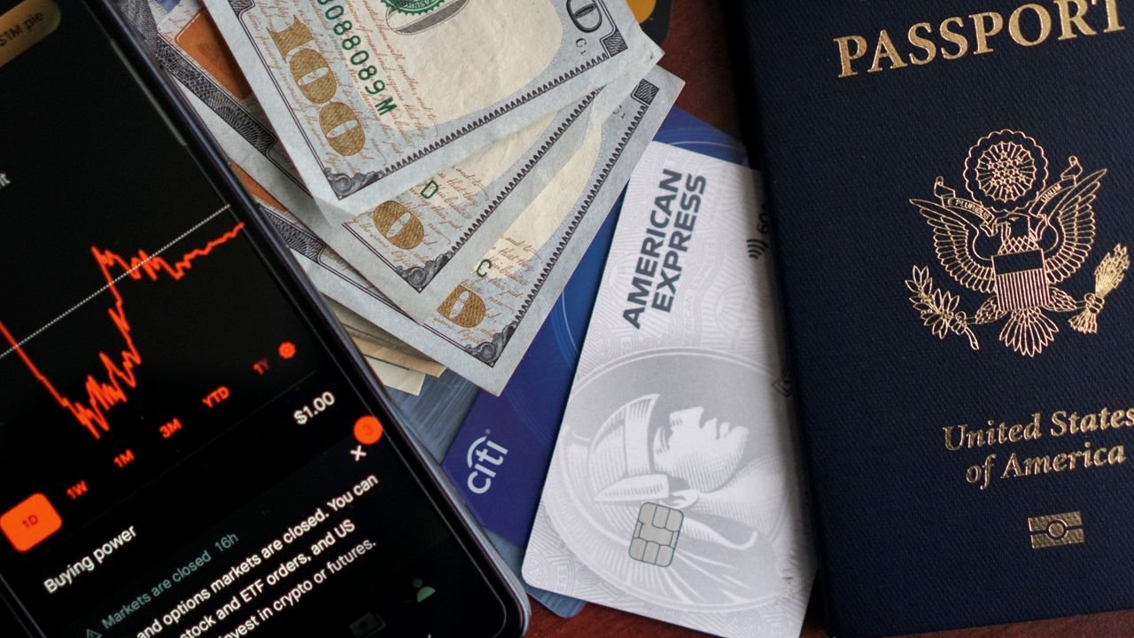 Stock trading concepts with passport, credit cards, cash, and smartphone app image.