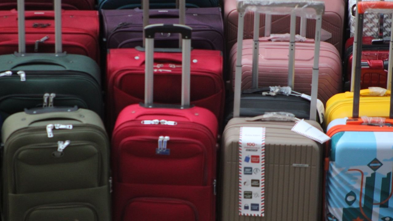 A vibrant collection of various suitcases stacked in preparation for travel.