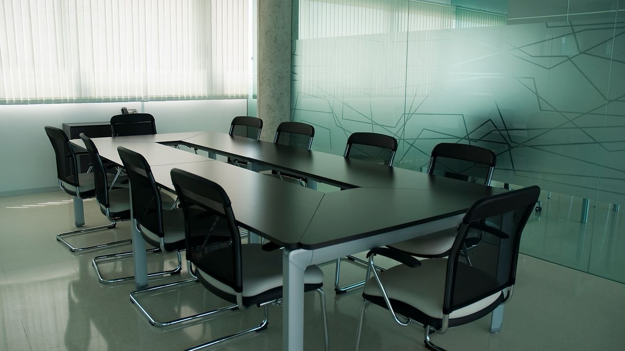 Elegant conference room with sleek black chairs and a modern glass wall design.