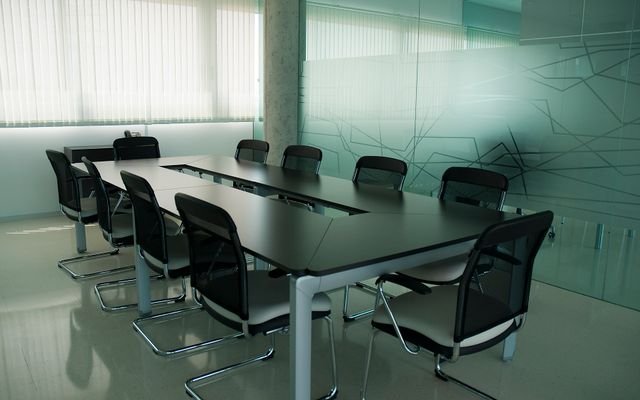 Elegant conference room with sleek black chairs and a modern glass wall design.