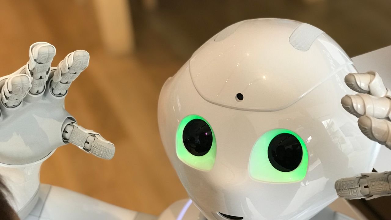 A futuristic humanoid robot with glowing green eyes in a modern setting.