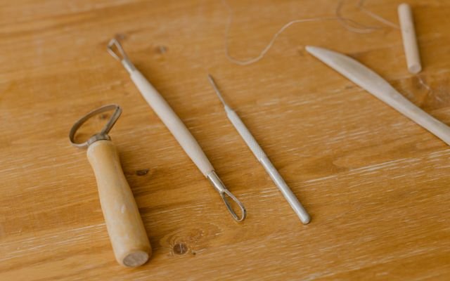 Close-up of various wood carving tools on a wooden surface, ideal for DIY projects.