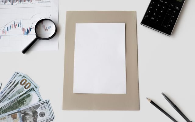 Flat lay of financial tools and blank paper for planning or mockup.