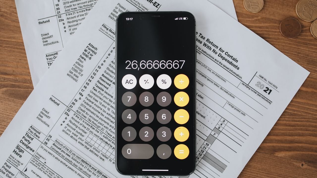 Mobile calculator app on tax documents, highlighting financial calculations and tax preparation.