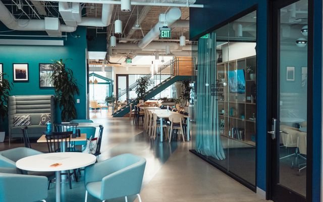 Open and collaborative modern office space with stylish furniture and natural lighting.